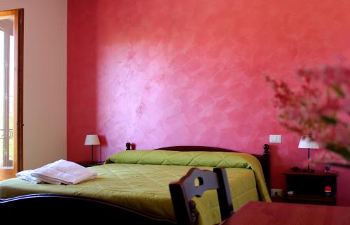 阿格里真托Agriturismo La Casa di Bacco的一间卧室配有一张绿色的床和粉红色的墙壁