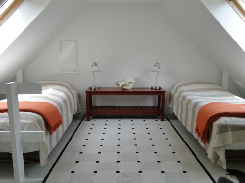 SkallerupDyssegaard B&B的阁楼卧室配有两张床和一张桌子
