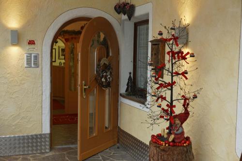科尔福索Alpin Apartments Colfosco的走廊上设有门和圣诞树