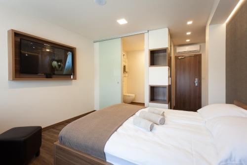 普图伊Hotel Pomaranča的卧室配有一张大床,墙上配有电视