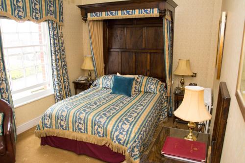 北沃尔舍姆比奇伍德酒店的一间卧室配有一张带木制床头板的床