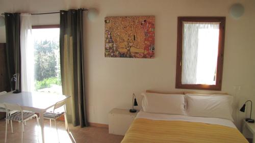 乌尔比诺Country House-B&B-Appartamenti Ai Cipressi的卧室配有床、桌子和窗户。