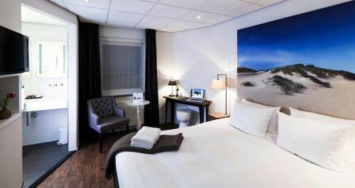 登堡斯暮尔博特精品酒店的酒店客房设有一张大床和一张书桌。