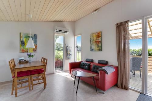 斯泰厄Ølholm Cottage的客厅配有红色的沙发和桌子