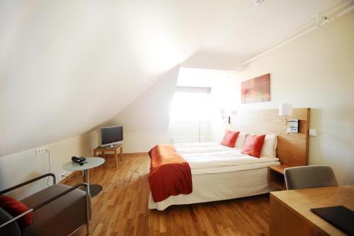 特隆赫姆施乐城市生活酒店的一间卧室配有一张床、一张书桌和一台电视。