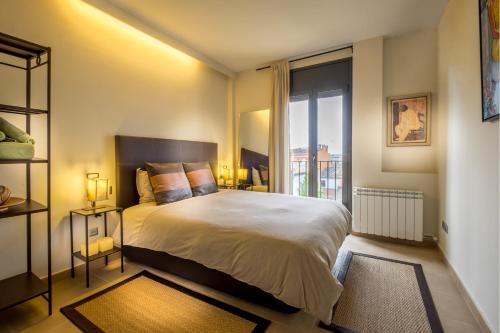 帕拉弗鲁赫尔Can Tarongeta Apartments的一间卧室设有一张大床和一个大窗户