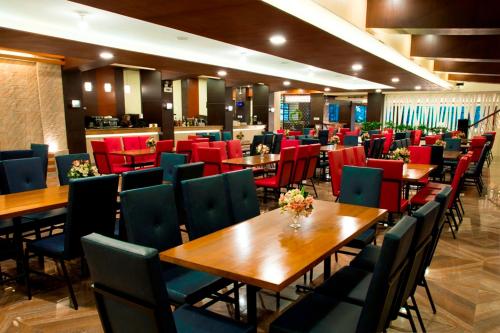 碧瑶维纳斯园景酒店的配有木桌和椅子以及红色椅子的餐厅