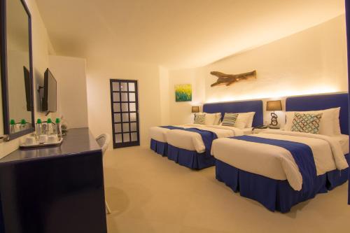 长滩岛长滩岛GT酒店的酒店客房设有三张床和电视。