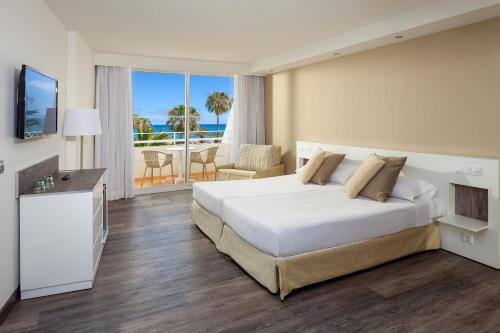 卡门港Sol Lanzarote - All Inclusive的一间卧室配有一张床,享有海景