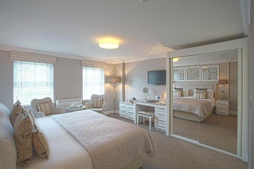 圣欧班广场酒店的一间卧室配有一张床和一张带镜子的书桌