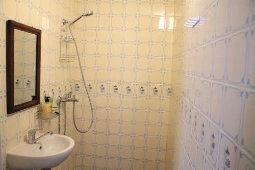维尔扬迪Trepimäe Guest Apartment的白色瓷砖浴室设有水槽和淋浴