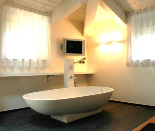 帕尔马世纪酒店的带电视的客房内的白色大浴缸