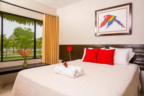 Padre CochaIrapay Amazon Lodge - Asociado Casa Andina的一间卧室配有一张带红色枕头的床和一扇窗户
