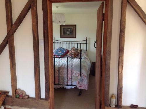斯托尔河畔希普斯顿啤酒花和葡萄藤公寓的一间卧室配有一张床和一个木制门廊