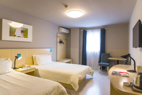 襄阳锦江之星襄阳南山檀溪路店的酒店客房设有两张床和窗户。
