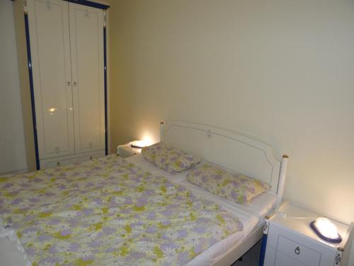 奥斯特巴德里克Apartmentanlage "Am Salzhaff"的卧室内的一张床位,两盏灯