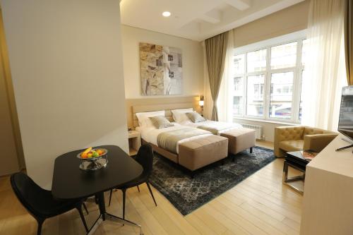 贝尔格莱德Zepter Hotel Belgrade, member of Zepter Hotels的一间卧室配有一张床、一张桌子和一张沙发