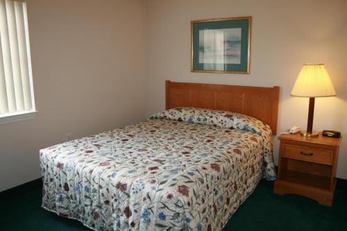 默特尔比奇默特尔比奇经济套房汽车旅馆的一间卧室配有一张床和一张带台灯的桌子