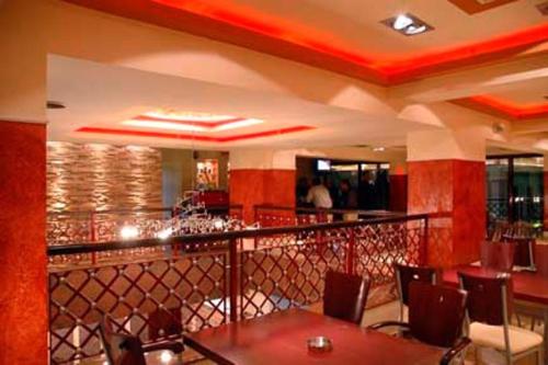 卡泰里尼奥林匹亚酒店的餐厅设有酒吧,配有桌椅