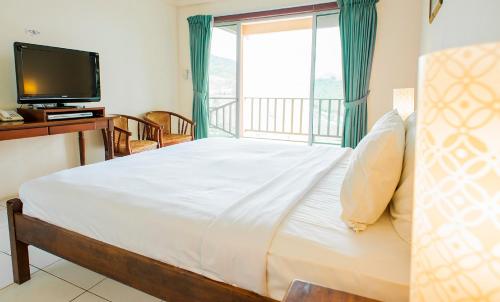 昆达桑京那巴鲁西岭度假酒店的一间卧室配有一张大床和电视