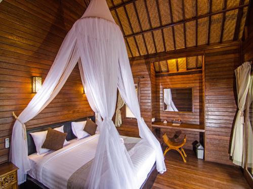蓝梦岛卡萨哇简易别墅酒店的一间卧室配有一张带蚊帐的床