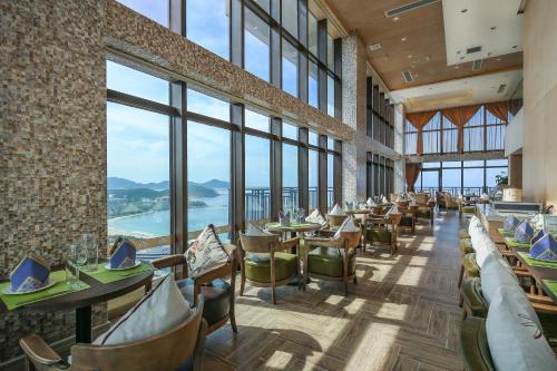 三亚三亚柏瑞精品海景酒店的餐厅设有桌椅和大窗户。