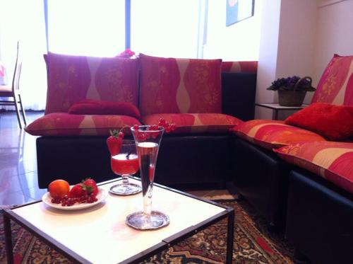 加比切马莱Hotel Aurora的客厅配有沙发和带2个眼镜的桌子
