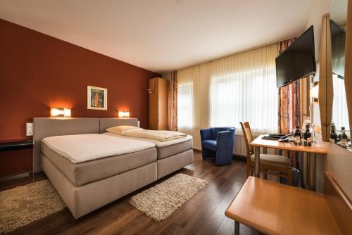 SüdlohnHotel & Gasthaus Nagel的配有一张床和一张书桌的酒店客房