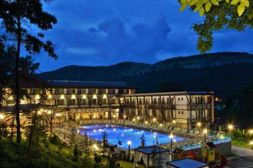 大特尔诺沃Park Hotel Asenevtsi的夜间设有游泳池的酒店