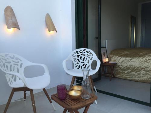 弗里希利亚纳Apartment Joaquin的一间设有两把白色椅子和一张床的房间