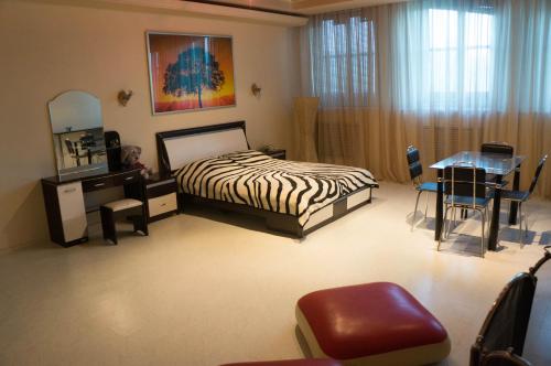 巴甫洛达尔Гостиница "Сапсан"的卧室配有1张床、1张桌子和1把椅子