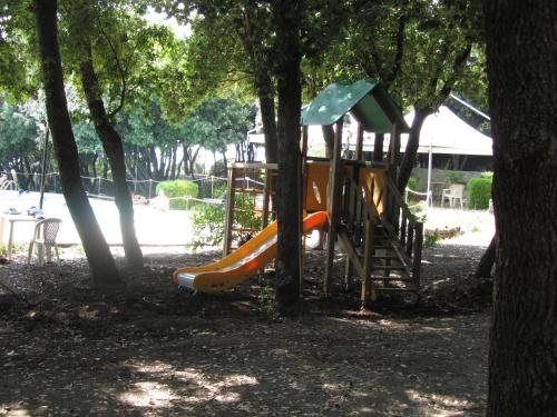 马拉泰亚伊利西尼酒店的树木繁茂的公园里一个带滑梯的游乐场