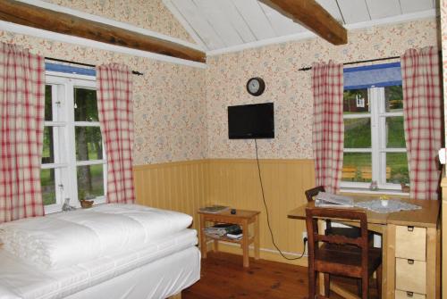 HauridaÅsens By的卧室配有一张床、一张书桌和窗户。