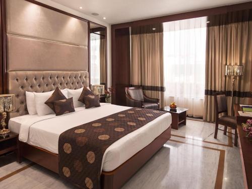 蓬蒂切里双威庄园酒店的酒店客房设有一张大床和一张书桌。