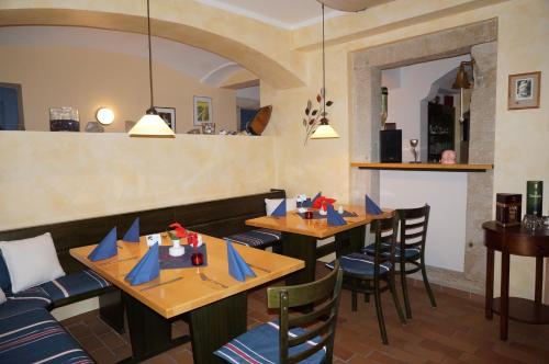 ReinhardtsdorfPension Goldener Anker的餐厅设有木桌和蓝餐巾