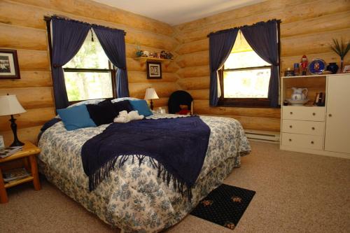 卡利斯佩尔The Garrison Inn a Montana Bed & Breakfast的一间卧室设有一张床和两个窗户。