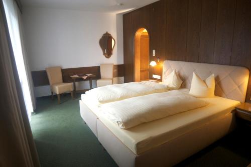 因斯布鲁克宋恩霍夫酒店的卧室配有一张白色大床