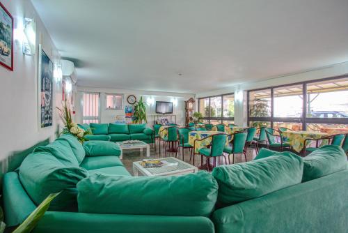 里米尼Hotel Diamante的一个带绿色沙发和桌子的大客厅