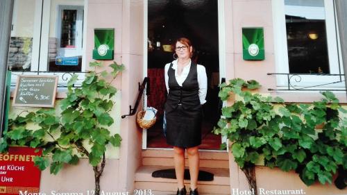 吕德斯海姆索马山酒店的站在房子台阶上的女人