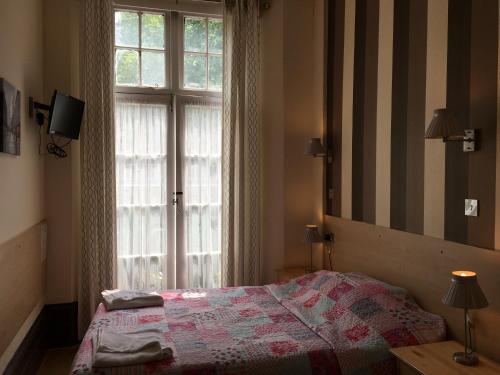 伦敦圣乔治酒店的一间卧室设有一张床和一个大窗户