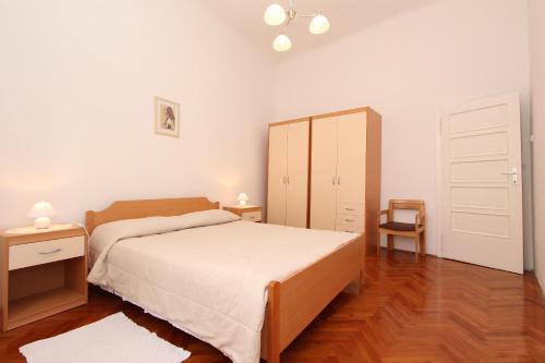 罗维尼里其公寓的一间卧室配有一张床、一个橱柜和一把椅子
