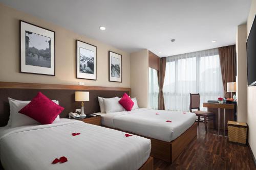 河内金月亮套房酒店 的酒店客房设有两张红色玫瑰床。
