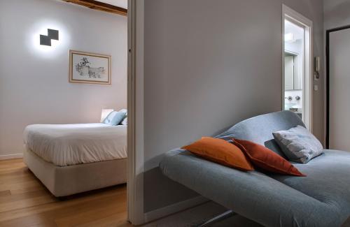 都灵维托里奥广场套房的一间卧室配有床和蓝色沙发及枕头
