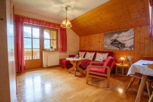 拉姆绍达赫斯坦Landhaus Birgbichler - Apartments mit Bergblick inklusive Sommercard的客厅配有红色的沙发和桌子