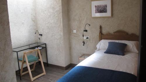 San Miguel de ValeroSueñoRural的卧室配有1张床、1张桌子和1把椅子