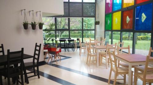 杜兰戈埃罗塔奥斯塔图旅馆的餐厅设有桌椅和彩色玻璃窗
