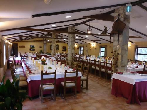 Los Navalucillos瓦尔多拉扎佐乡村民宿的一间设有白色桌椅的用餐室