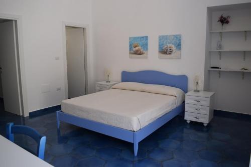 普罗奇达西罗度假屋的一间卧室设有蓝色的床和白色的墙壁