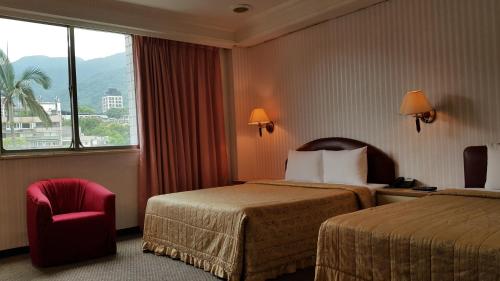 台北东皇渡假旅店的酒店客房带两张床、椅子和窗户