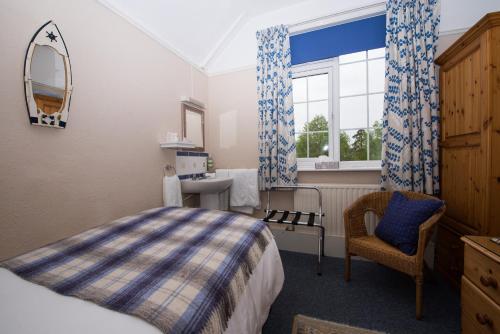 海斯The Maples的卧室配有床、椅子和窗户。
